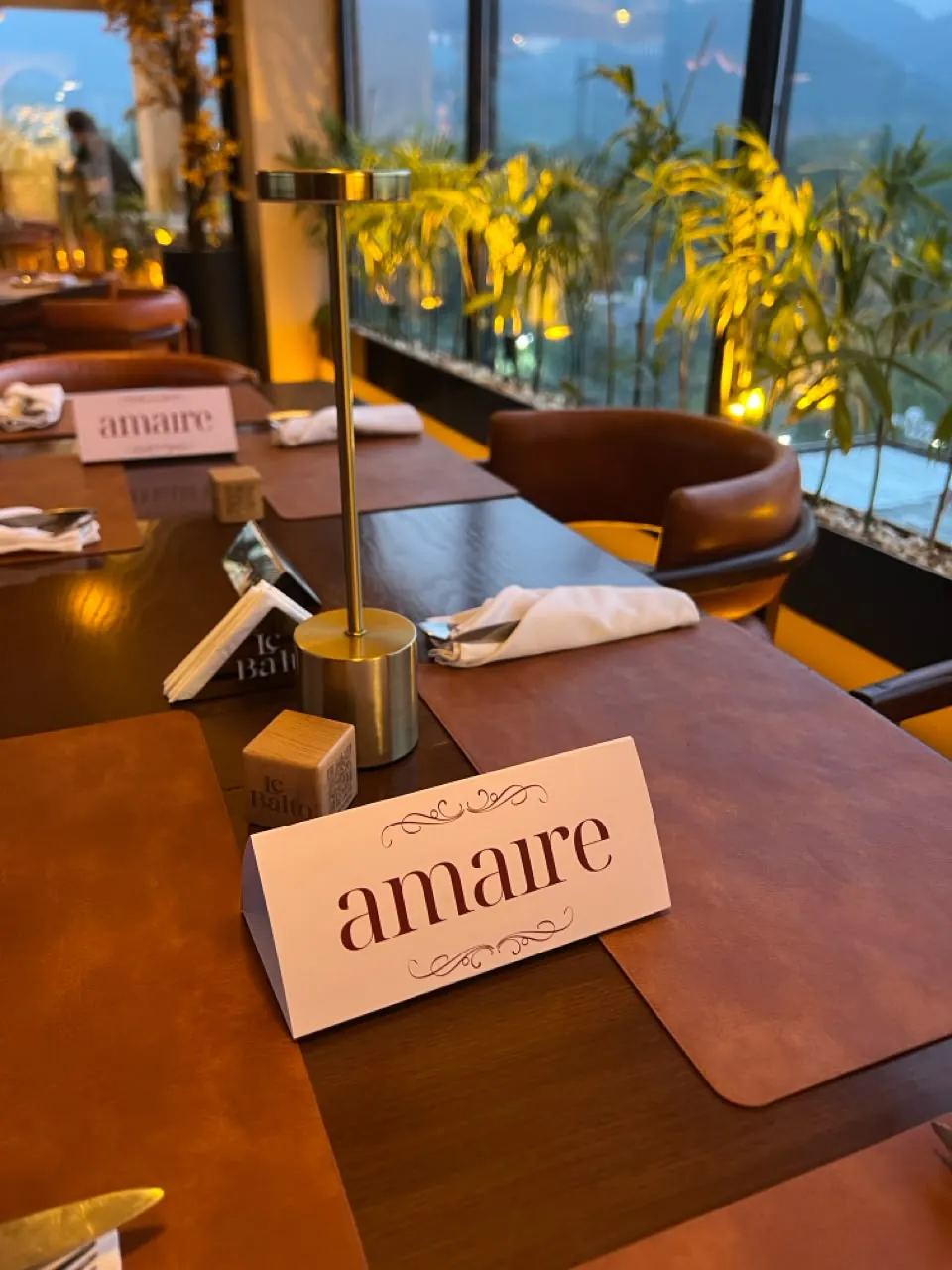 An Amaire place card on a warmly lit dinner table